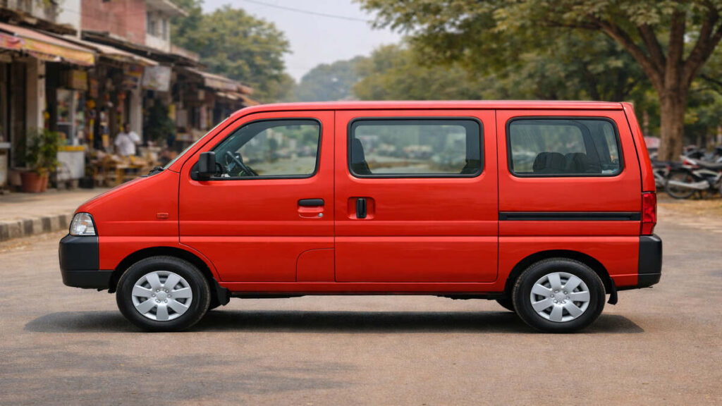 Red Maruti Suzuki Eeco side profile parked on a small town street.