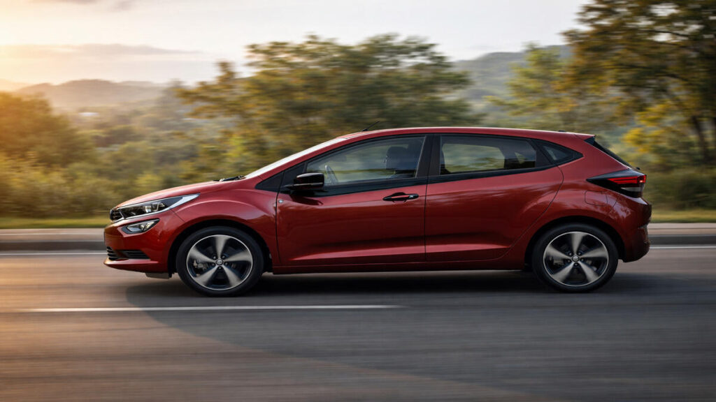 Tata Altroz EV side profile driving on an open road in soft evening light with natural motion blur
